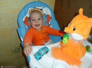 малыш смеется в ответ поющей игрушке.